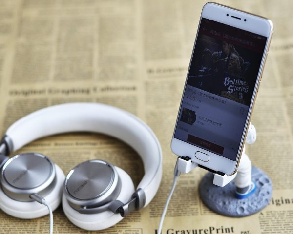 年轻女性戴着头戴式耳机在暗蓝色霓虹灯光的卧室中闭眼聆听asmr online助眠音频，画面宁静而科技感十足，绿色光晕萦绕